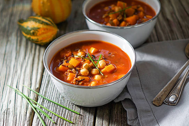 Vegetarian tasty spicy chili chick pea pumpkin wild rice soup pozole stew bowl on a wooden background